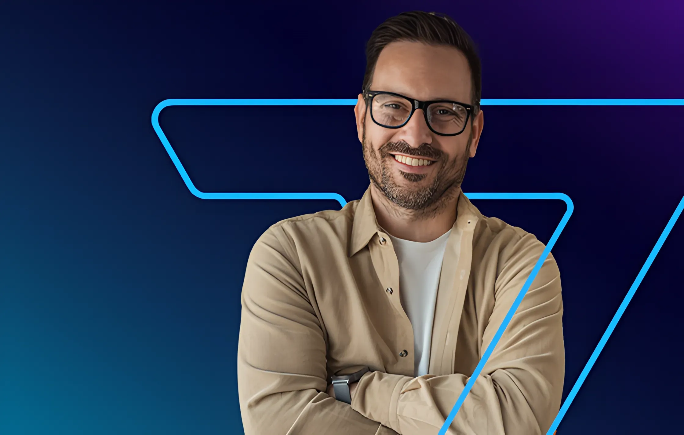 homem de oculos sorrindo e com braços cruzados